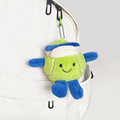 Green and blue plush tennis bag charm clipped to a white tennis backpack